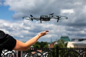 persona en un balcón con la mano extendida y un dron volando sobre esta