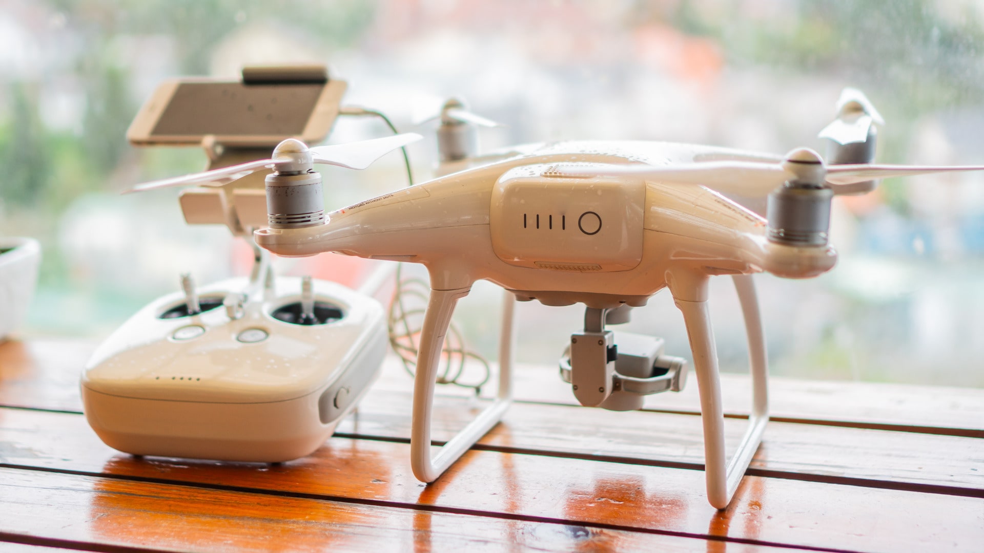 dron ligero apoyado en una mesa junto a su control remoto