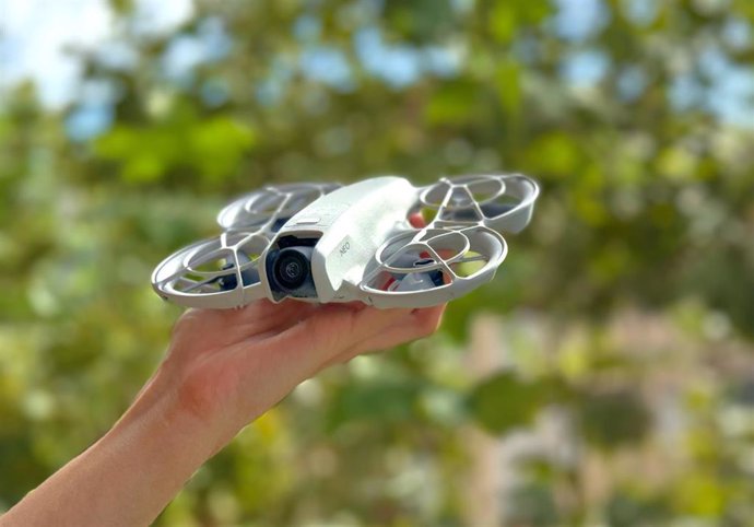 dron en la palma de una mano con árboles de fondo