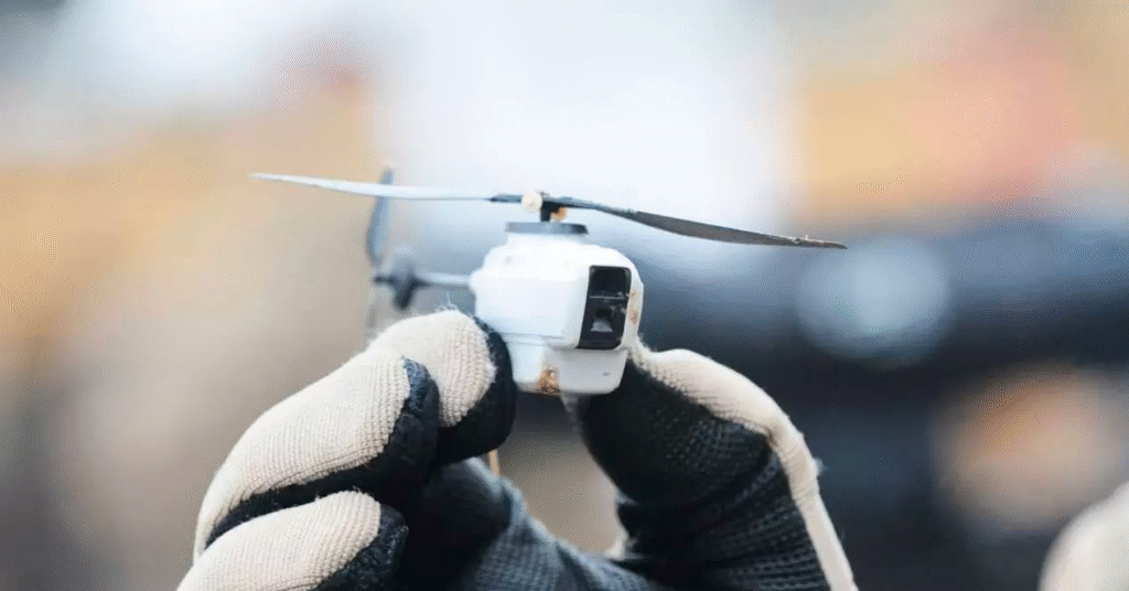 persona sujetando un mini dron entre sus dedos