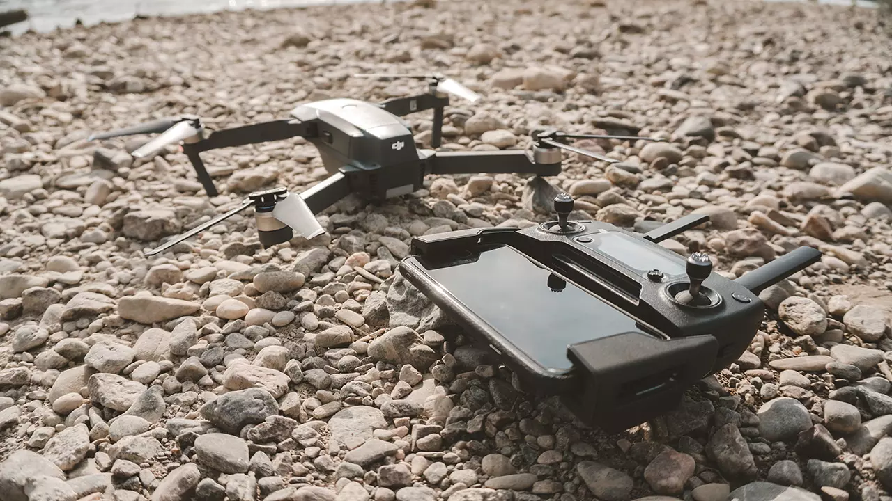 microdron junto a su control remoto apoyados en el suelo