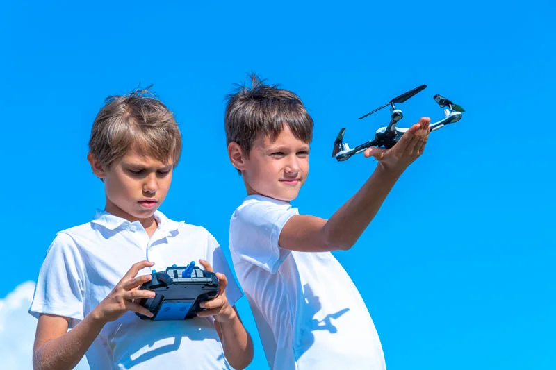 dos niños jugando con un dron